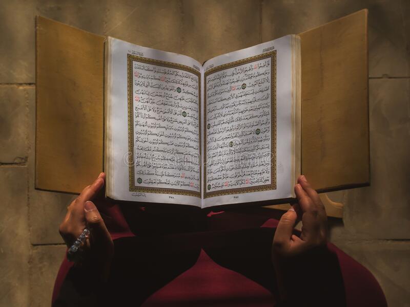 a Muslim woman holding open Quran